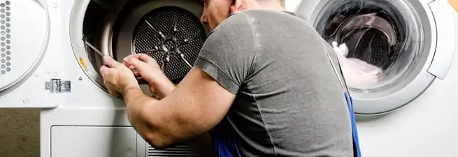 Dryer repair technician fixing a clothes dryer drum in Las Vegas, NV