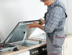 Appliance repair technician installing a built-in cooktop in Las Vegas, NV