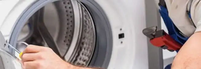 Appliance technician repairing a clothes dryer drum and internal parts in Las Vegas, NV