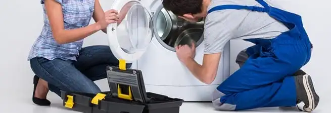 Washer repair technician inspecting a front-load washing machine with tools in Las Vegas, NV