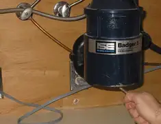 Garbage disposal repair technician tightening the mounting ring under a sink in Las Vegas, NV