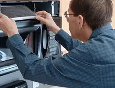 Appliance repair technician replacing a microwave vent filter in Las Vegas, NV