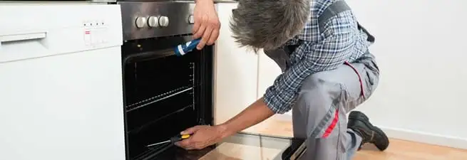 Oven repair technician inspecting and servicing an electric oven in Las Vegas, NV