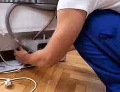 Appliance repair technician fixing refrigerator water line and connections in Las Vegas, NV