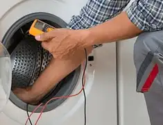 Washing machine repair technician testing a front-load washer with diagnostic tools in Las Vegas, NV