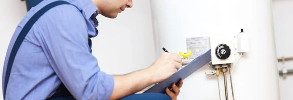 Water heater repair technician inspecting the unit and recording service notes in Las Vegas, NV