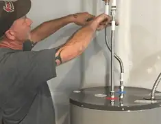 Water heater repair technician tightening supply line connections in Las Vegas, NV