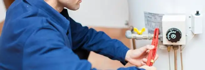 Water heater repair technician adjusting the temperature control and gas valve in Las Vegas, NV